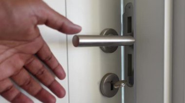 Bir el zarif ve modern bir kapı koluna uzanıyor, bir girişi davet ediyor.