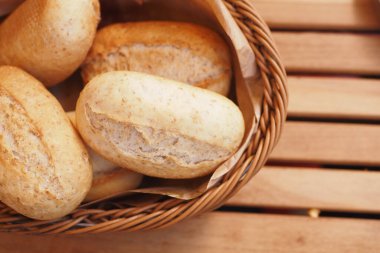 Hasır bir sepette güzelce sergilenen lezzetli ve taze ekmek ruloları.