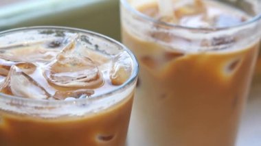 Kafe masasında şeffaf bir bardakta buzlar eridi. ,