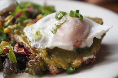 Kremalı avokado tostlu haşlanmış yumurta ve canlı bir salata tabağı güçlendiriyor.