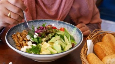 Çeşitli taze sebzeler ve renkli sebzelerle dolu canlı bir salata kasesi.