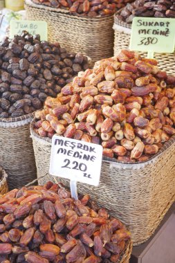 Canlı bir pazarda dokuma sepetlerinde çeşitli kurutulmuş tarihlerin renkli bir görüntüsü düzenlenir.