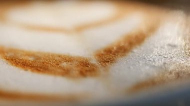 Nefis bir latte sanat eseri. Köpüklü kahvenin üzerinde büyüleyici desenler sergiliyor.