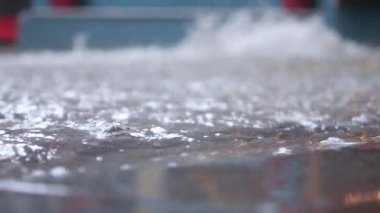 Sel basmış bir yüzeyin detaylı bir yakın çekimi su sıçratır ve büyüleyici yansımaları