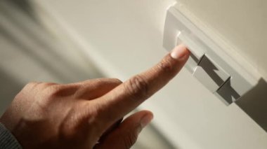 Işık düğmesini açan bir parmak
