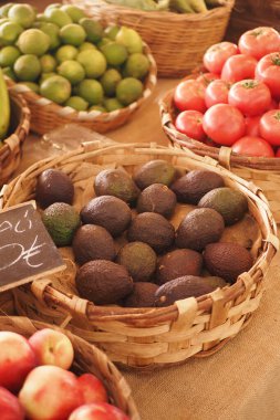 Hareketli bir piyasa, canlı, taşra sepetlerinde mevsimsel meyvelerin sergilendiği bir gösteri sunuyor.