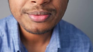 Bir erkeğin çekici dudaklarını ve çenesini gösteren dramatik bir yakın çekim görüntüsü, samimiyeti vurguluyor.