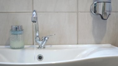 Modern aksesuarlar ve şık bir cam kap içeren gösterişli banyo lavabosu tasarımı.