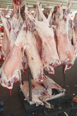 Canlı ve canlı bir pazar ortamında taze, kaliteli et parçaları asılı.