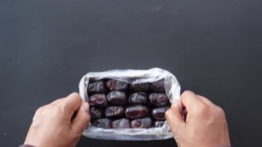 Bir insan, zıt bir karanlık arka plana karşı temiz bir tarih çantası tutar.