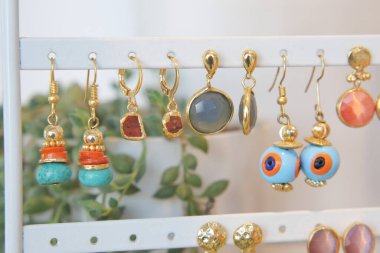 Bir dizi göz alıcı, renkli küpe zarif bir şekilde vitrinde sergilenir.