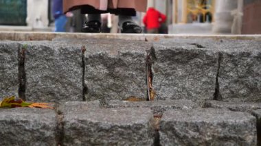 Kaliteli ayakkabıların yanında güzel desenli kaldırım taşı basamaklarının detaylı bir yakın görüntüsü