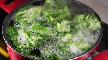 Taze brokoli sobanın üstünde, ahşap bir kaşıkla taze brokoli, sağlıklı pişirme hazırlığı sergiliyor..