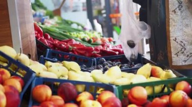 Yerel bir pazarda müşteriler için renkli bir taze meyve ve sebze gösterisi.