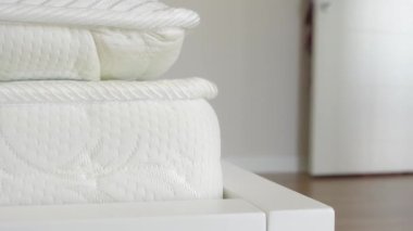 Örgü desenli ve nötr tonlu beyaz bir yatak yakın çekim görüntüsünde rahat bir deneyim sunar.