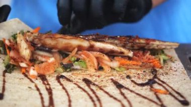 Renkli sebzeli ızgara balık, çıtır bir taco kabuğunda, aromalı sosla süslenmiş.
