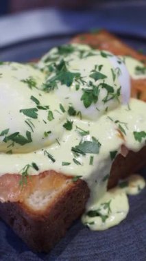 Kızarmış ekmeğin üzerinde kaynamış yumurta, harika bir kahvaltı için kremalı hollandaise sosu.