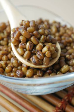 Lezzetli, mükemmel pişirilmiş mung fasulyeleri ahşap bir kaşıkla güzel bir kasede servis edilir.