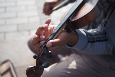 Müzisyenlerin ellerinin keman çalması, enstrüman ve tekniğe odaklanması.