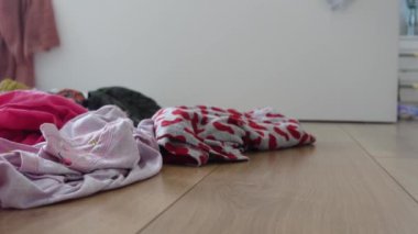 Canlı, renkli bir kırışık elbise koleksiyonu açık ahşap bir zemine saçılmış.