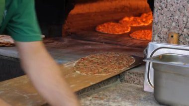 Tecrübeli bir aşçı ustalıkla pizza hamurunu güzel bir kır fırınının içinde hazırlar.