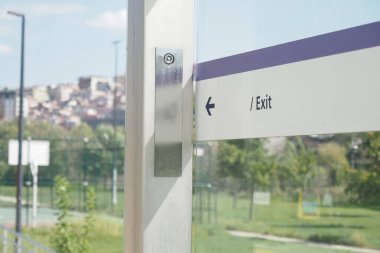 Bir otobüs durağında manzaralı bir park ortamında açık çıkış yönlerini gösteren çağdaş tabela