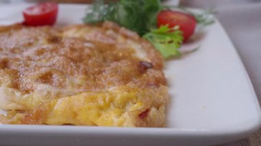 Kiraz domatesleri ve taze bitkilerle birlikte yeni yapılmış nefis bir omlet.