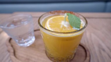 Canlandırıcı naneli ve lezzetli limonlu canlı bir portakal suyu. Yaz tatili için ideal.