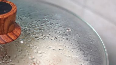 Yoğunlaşma ve ahşap saplı cam kap kapağının detaylı bir yakın görüntüsü