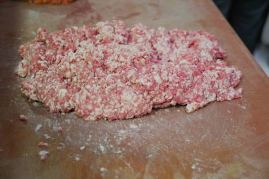 Temiz bir mutfak yüzeyine yerleştirilmiş çiğ et, pişirilmeye hazır olmak için bekliyor.