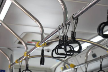 Stratejik olarak yerleştirilmiş emniyet çubuklarını gösteren bir toplu taşıma otobüsünün iç görünümü