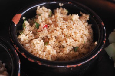 Bu lezzetli kuskus taze otlar ve baharatlarla yapılır, kırsal bir kasede servis edilir.