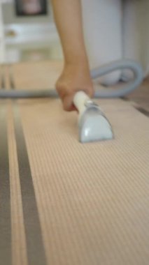 Halıda elektrikli süpürge kullanan, şık bir evde temizlik sağlayan bir el..