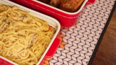 Lezzetli bir makarna ve canlı kırmızı tabaklarda servis edilen leziz bir tavuk.