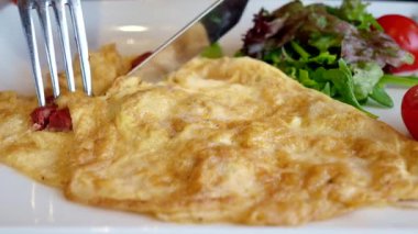 Şaşırtıcı derecede güzel sarı bir gül, canlı yeşil yapraklara nazikçe ve sevgiyle sarılmış.