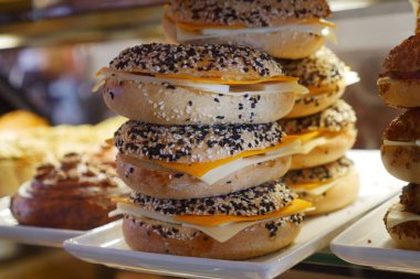 Zengin peynirlerle dolu istiflenmiş çörekler, büyüleyici bir pastanede güzelce sergileniyor.