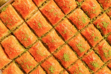 Şam fıstığı kırıntılarıyla serpiştirilmiş otantik baklava dilimlerinin tadını çıkarın.