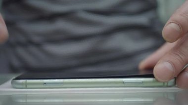 Eğim ve tasarım özellikleri için akıllı telefonu inceleyen bir bireyin yakınlaşması