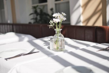 Dekorasyon için muhteşem bir çiçek süsü sergilenen güzel bir yemek masası.