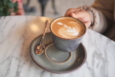 Nefis bir el yapımı latte pürüzsüz mermer bir masada dinleniyor.