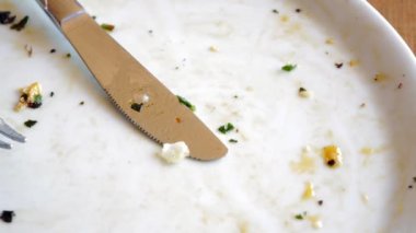 Kalıntılarla süslenmiş, lezzetli bir yemeğin neticesini gözler önüne seren kullanılmış bir tabak.