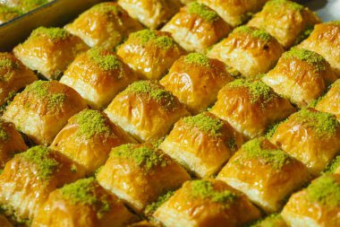 Şam fıstığı kırıntılarıyla serpiştirilmiş otantik baklava dilimlerinin tadını çıkarın.