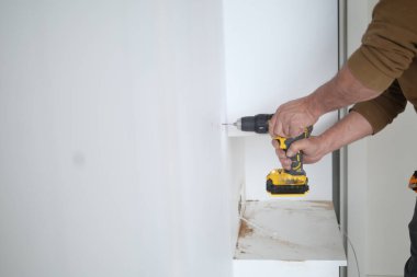  Beyaz tahta üzerinde elektrikli matkap kullanarak. .