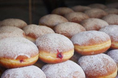Taze, kabarık çörekler pudra şekerle kaplanmış, içinde tatlı böğürtlen tozu var..