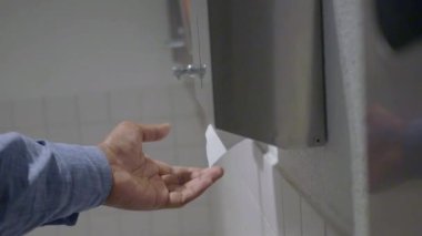 Temiz umumi tuvaletteki beyaz fayanslı bir kutudan kağıt havlu alıyorum..