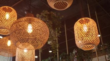 Zarif rattan kolye ışıkları rahat bir kafede sıcak ve davetkar bir atmosfer yaratıyor.