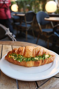Taze otlar ve lezzetli malzemelerle dolu gurme bir kruvasan. Her yemek için mükemmel.