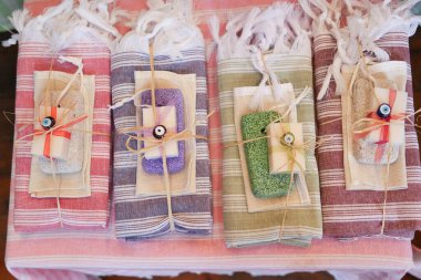 Güzel dizilmiş el yapımı sabunluklar ve katlanmış havlular, büyüleyici bir gösteri için kurdeleyle sarılmış..