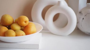 Çağdaş dekoratif elementlerle geliştirilmiş taze kayısıların zarif ve şık bir düzeni.