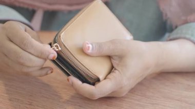 Kadınlar çantasının fermuarını açıyorlar.,